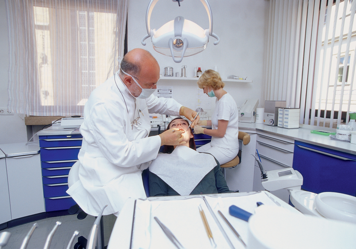 Orthodontist adjusting braces